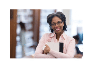 A woman holding a folder in a library, smiling